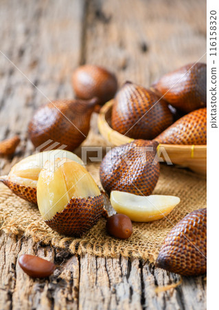 Salak (Salacca zalacca) or Snake fruits on sack and on old wood background, 116158320