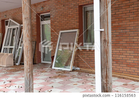 View of the unfinished wall of the house. New windows in the house. 116158563