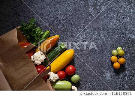 Paper bag full of different healthy food isolated on white background. Top view. Paper bag full of different healthy food isolated on white background. Top view. 116158591