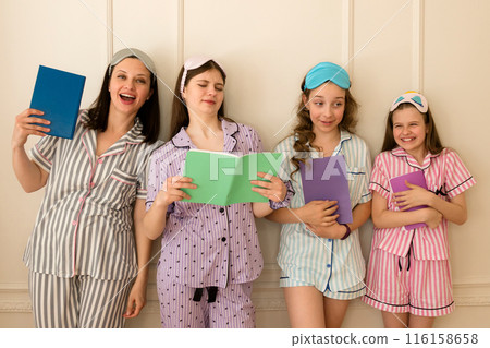 Woman and group girls in striped pajamas holding books 116158658