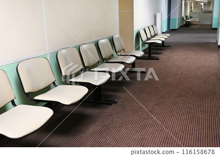 Empty hospital waiting room in lobby with reception counter at medical facility, used to help patients with appointments and healthcare insurance. Medical waiting area with front desk. 116158678