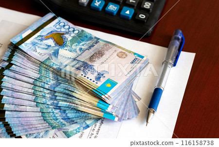 Tenge. Paper Kazakh money and calculator on the table close-up. 116158738