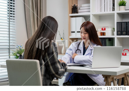 Female Doctor Consulting Patient in Modern Office with Laptop and Medical Equipment 116158788