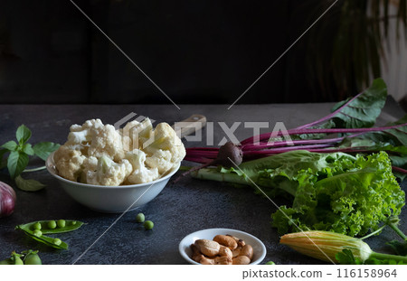 Cauliflower with vegetables and spices on a dark wood background 116158964