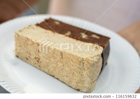 Chocolate halva piece on a paper plate, brown halawa also known as halawa, alva, haleweh, halava 116159632