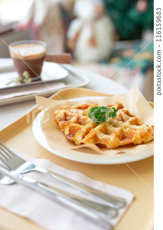 Close up croffle or croissant waffle with a coffee in a coffee shop 116159683