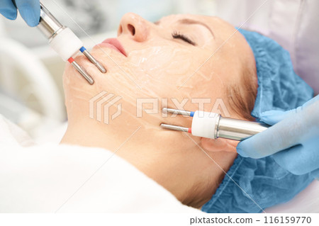 Dermatology anti age treatment. Microcurrent medicine procedure. Woman 116159770
