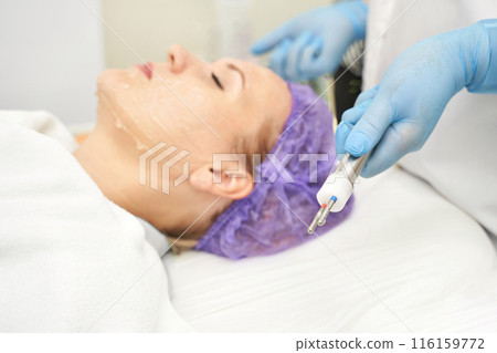 Dermatology anti age treatment. Microcurrent medicine procedure. Woman 116159772