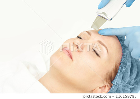 Ultrasound cosmetology scrubber. Face cavitation procedure. Salon skin treatment Ultrasound cosmetology scrubber. Face cavitation procedure. Salon skin treatment 116159783