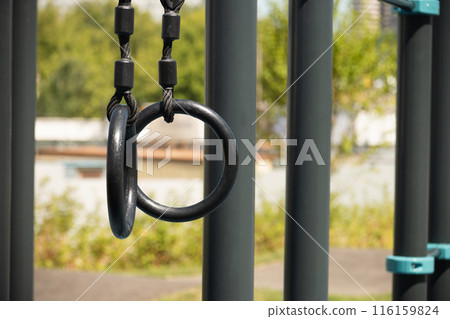 Gymnastic rings to strengthen the arms on street sport ground. Outdoor sports field. Healthy lifestyle. Close up. Gymnastic rings to strengthen the arms on street sport ground. Outdoor sports field. Healthy lifestyle. Close up. 116159824