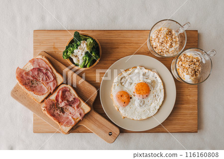 Easy breakfast set of ham fired eggs broccoli and yogurts. 116160808