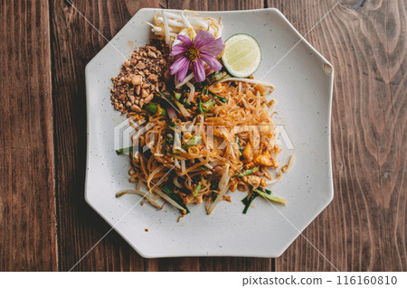 Above angle view of luxury style of Pad Thai dish decorated with purple flower. 116160810