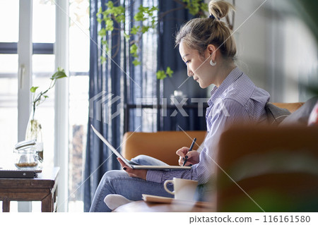mature asian woman working from home using notebook computer mature asian woman working from home using notebook computer 116161580