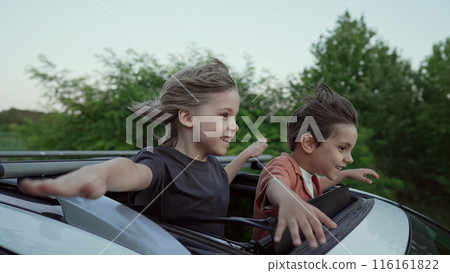 Funny Happy Little Boys Stands In Open Car Sunroof During Trip, Summer.Childhood Funny Happy Little Boys Stands In Open Car Sunroof During Trip, Summer.Childhood 116161822