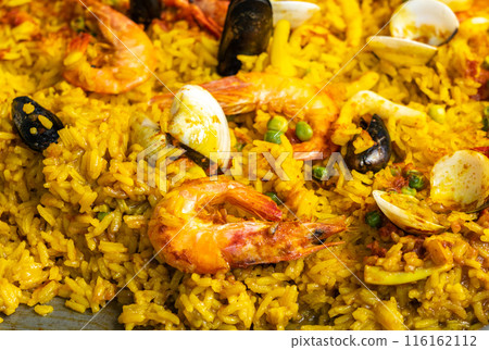 Seafood paella, Spanish rice dish with shrimp, mussels, clams, yellow rice in large pan, traditional paella 116162112