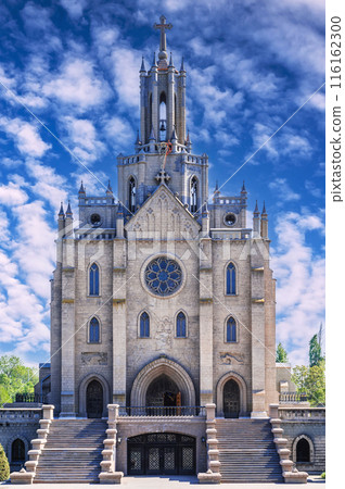 exterior of the gothic old Catholic Cathedral on background of blue cloudy sky in spring. Polish Church Cathedral of Sacred Heart of Jesus in Tashkent in Uzbekistan 116162300
