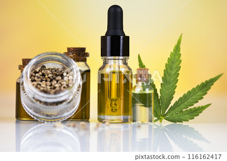 Hemp oil and cannabis leaves on light background Hemp oil and cannabis leaves on light background 116162417