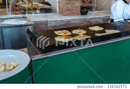 Msemen cooking process, hotel breakfast, hot griddle flatbreads, dough preparation, flipping 116162571