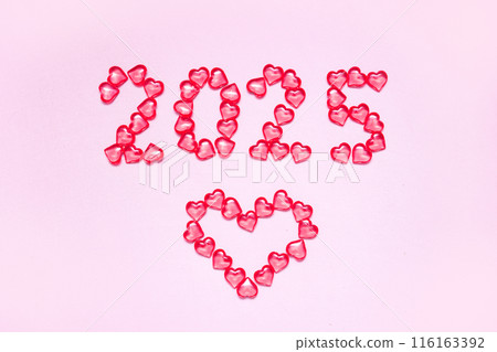 New Year 2025 inscription from glass hearts on a pink background. Pantone color 2025. Idea and creativity. Valentine's Day. Christmas with loved ones. Horizontally, banner. High quality photo 116163392