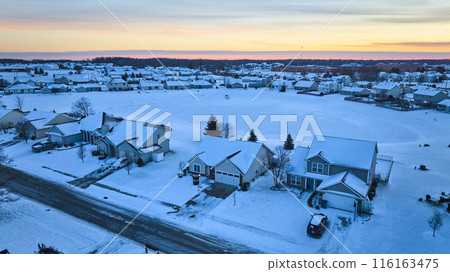 Aerial Winter Suburb at Dusk - Snowy Residential Area with Sunset Hues 116163475
