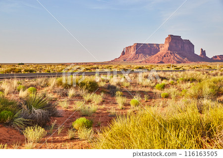 Late Afternoon Desert Road with Red Sandstone Buttes in Arizona Late Afternoon Desert Road with Red Sandstone Buttes in Arizona 116163505