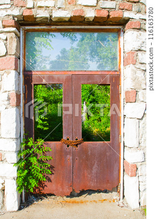 Rusty Double Doors in Stone Frame with Nature's Overgrowth, Rural Missouri Rusty Double Doors in Stone Frame with Nature's Overgrowth, Rural Missouri 116163780