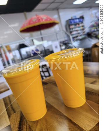 Two Mango Lassi Beverage Cups in Modern Restaurant, Close-Up Perspective 116163993