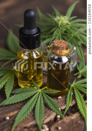 Cbd hemp oil in bottle and marijuana leaves 116164058