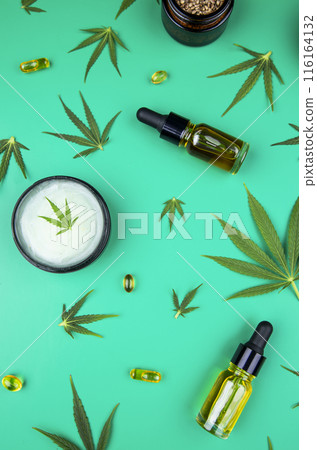 Composition with hemp oil cbd and bottle of oil on green background Composition with hemp oil cbd and bottle of oil on green background 116164132