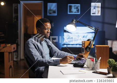 Self employed person shopping online for clothes, working from home and adding card numbers to finish webpage payment. Young worker with freelance contract buying products on sale. 116165601