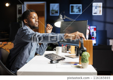 System admin generating IT scripts for data centers and developing program in machine language. On HTML terminal window, engineering specialist typing code in binary, ensures server security. 116165693