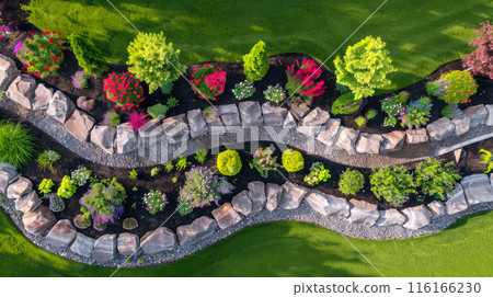 Aerial top view of terraced home garden and stone retaining walls, landscape design of house back yard. Beautiful flowers at backyard. Concept of landscaping, plants, nature 116166230