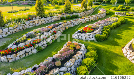 Landscaped home garden with terraces and rocks, beautiful design of luxury house backyard, stone retaining walls in summer. Concept of landscaping, back yard, plants, flower 116166232