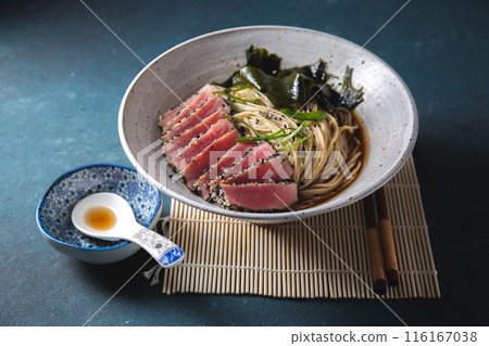 A bowl of ramen featuring perfectly seared tuna slices, garnished with fresh greens, seaweed, and served in a savory broth. A bowl of ramen featuring perfectly seared tuna slices, garnished with fresh greens, seaweed, and served in a savory broth. 116167038