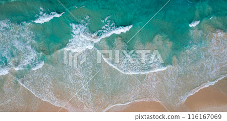 A breathtaking aerial view of a pristine beach in the Dominican Republic, featuring turquoise waves crashing onto soft golden sands. 116167069