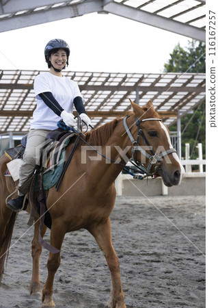 Woman enjoying horse riding Woman enjoying horse riding 116167257