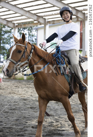 Woman enjoying horse riding 116167262