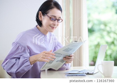 一個戴老花鏡看英文報紙的中年婦女 116167360