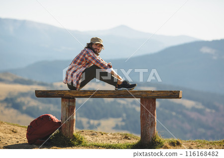 Male Hiker Resting on Bench in Carpathian Mountains, Ukraine Male Hiker Resting on Bench in Carpathian Mountains, Ukraine 116168482