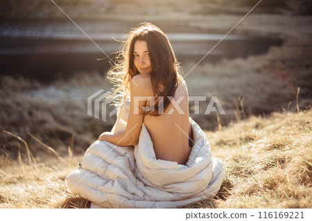 Woman Wrapped in Blanket Smiling by Nesamovyte Lake in Carpathians 116169221