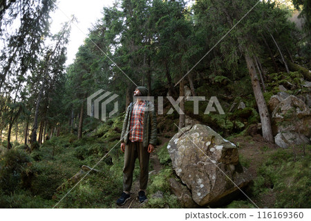 Hiker Exploring Lush Forest in Carpathian Mountains Hiker Exploring Lush Forest in Carpathian Mountains 116169360