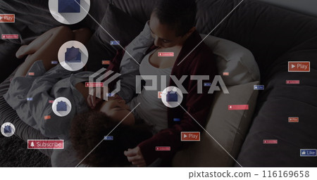 Image of social media icons over biracial mother embracing her daughter on the couch at home Image of social media icons over biracial mother embracing her daughter on the couch at home 116169658