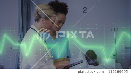 Image of heart rate monitor over diverse female doctor and health worker discussing at hospital 116169695