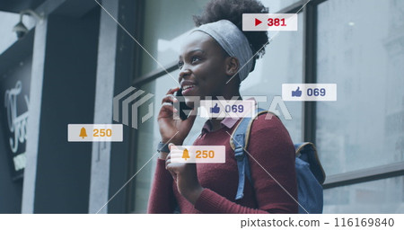 Image of social media icons over african american woman talking on smartphone outdoors Image of social media icons over african american woman talking on smartphone outdoors 116169840