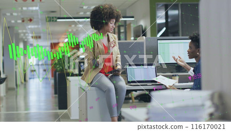 Image of multiple graphs with changing numbers, diverse female coworkers discussing on desk Image of multiple graphs with changing numbers, diverse female coworkers discussing on desk 116170021