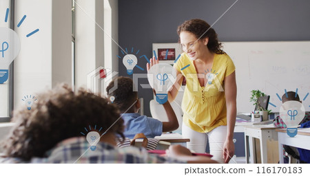 Image of light bulbs over diverse female teacher and schoolboy high fiving in class Image of light bulbs over diverse female teacher and schoolboy high fiving in class 116170183