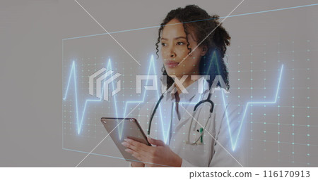 Image of heart rate monitor over african american female doctor using digital tablet at hospital Image of heart rate monitor over african american female doctor using digital tablet at hospital 116170913