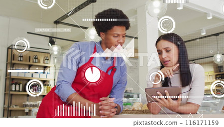 Image of multiple graphs moving over diverse coworkers discussing over tablet in office 116171159