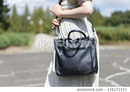 Young woman carrying a shoulder bag Young woman carrying a shoulder bag 116171553
