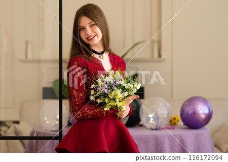 Teen girl in red lace dress holding bouquet of flowers 116172094